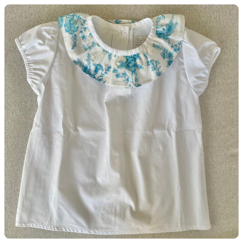 Remera blanca cuello flores turquesa