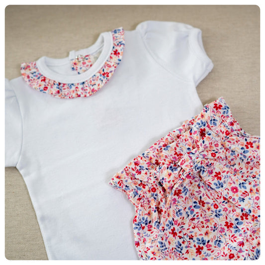 Body algodón blanco cuello flores fuccia